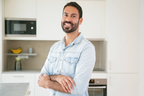 istock Happy handsome dark haired Latin man posing with arms folded 1264046587