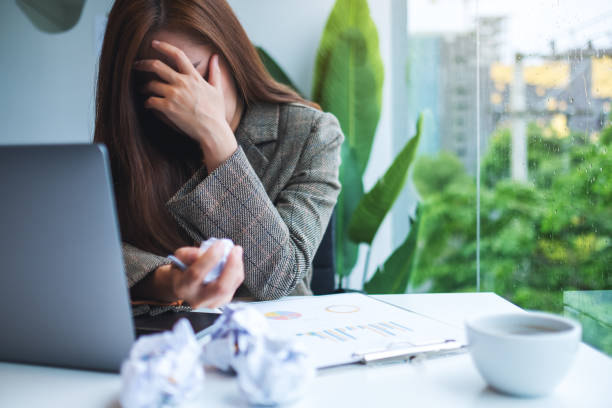 istock Businesswoman get stressed with screwed up papers and laptop on table while having a problem at work 1264047225