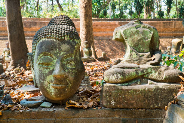 istock Buddha image statue damaged in temple outdoor background. Buddha image ruined with head and body in wat or temple, Thailand 1264049278