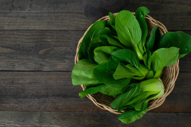 istock Fresh baby Bok choy in basket on wooden table. 1264049683