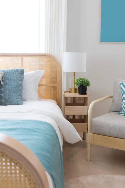 istock Elegant bedroom interior with lamps over bedside tables, comfortable bed, blue pillow and blanket. 1264049770