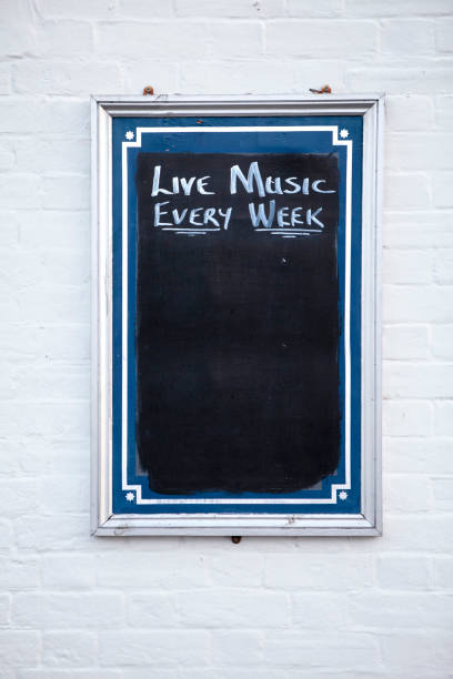 istock Live music notice written on pub blackboard on white brick wall with copy space 1264049780
