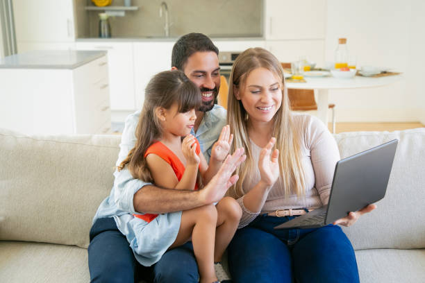 istock Happy parents and cute daughter using laptop for video call 1264054290