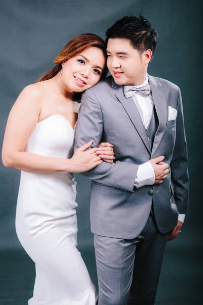 istock Young asian groom and bride posing and smiling in studio for pre-wedding shot 1264054845