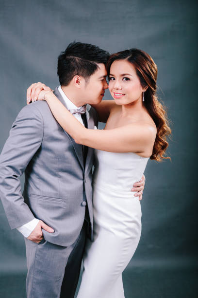 istock Young asian groom and bride posing and smiling in studio for pre-wedding shot 1264054853