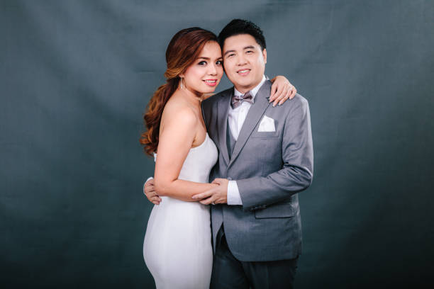 istock Young asian groom and bride posing and smiling in studio for pre-wedding shot 1264054871