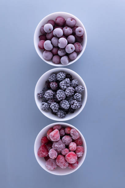 istock Frozen berries in a white bowls on a gray background. 1264054895