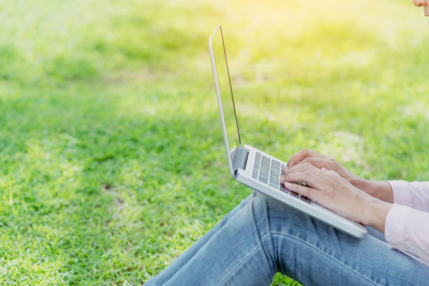 Asian woman sitting green park using laptop computer. Woman working on laptop happy entrepreneur business using notebook with hands typing on keyboard home office during coronavirus quarantine period asiática mujer sentada parque verde usando computadora portátil. mujer que trabaja en el negocio de emprendedores felices portátil usando portátil con las manos escribiendo en la oficina del teclado en casa durante el período de cuarentena del coronav