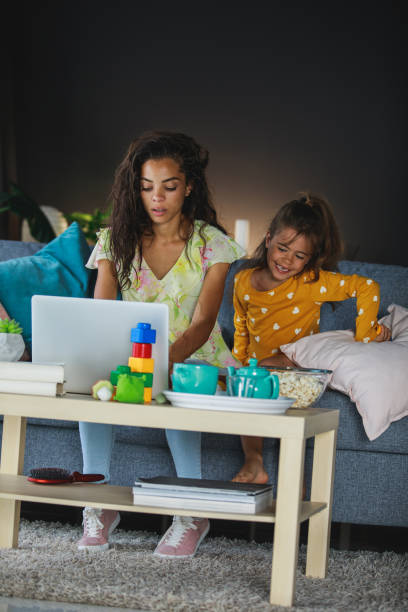 istock Adult mother sits on her sofa while answering business e-mails 1264056077