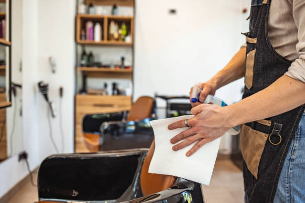 istock Male Barber cleaning equipment with alcohol spray 1264056132