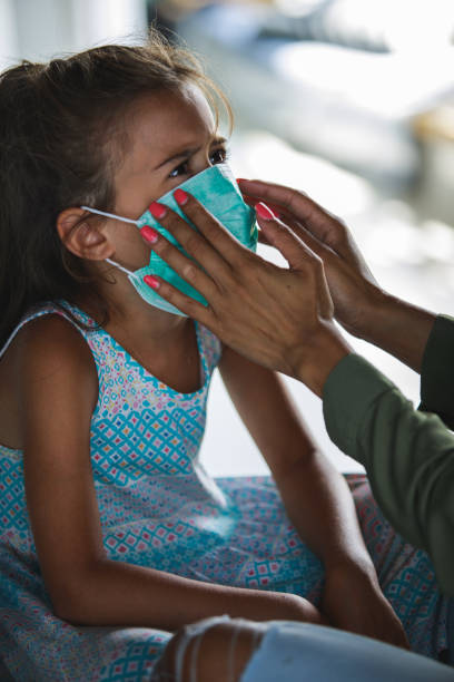 istock Mother adjusting mask on daughter's facce 1264057518