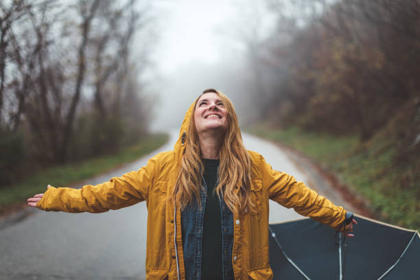 istock Joyful woman walking in rainy weather 1264059629