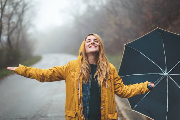 istock Joyful woman walking in rainy weather 1264060227