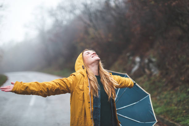 istock Joyful woman walking in rainy weather 1264060271