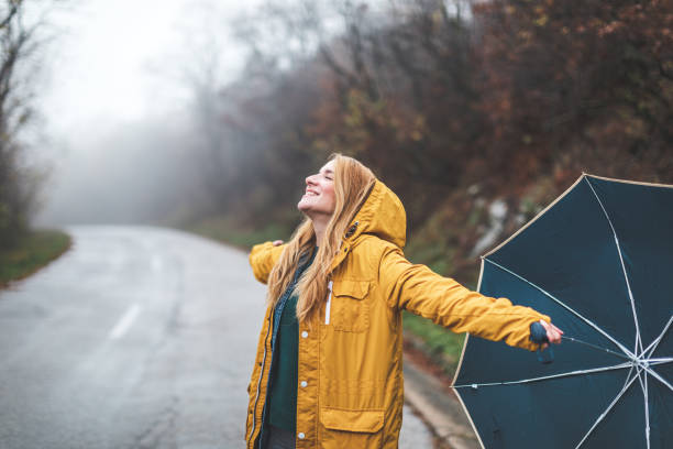 joyful woman walking in rainy weather - winter women zen like photography imagens e fotografias de stock