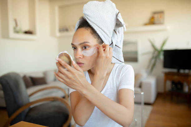 istock Young African American woman applying makeup on her face 1264062518
