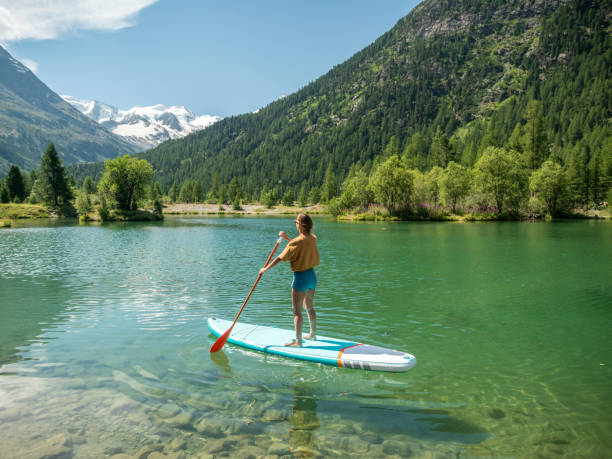 istock Stand up paddle with a view, woman on SUP in the mountains looking at glacier 1264064228