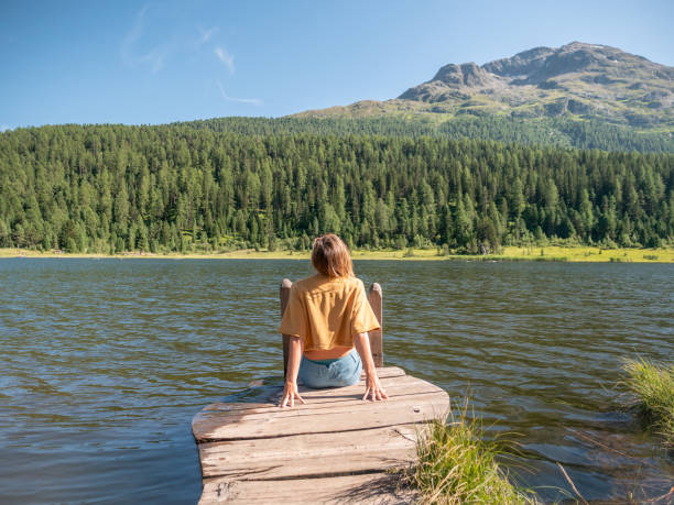 istock Young woman relaxing on lake pier 1264064560
