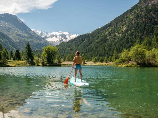 istock Stand up paddle with a view, woman on SUP in the mountains looking at glacier 1264065962