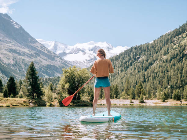 istock Stand up paddle with a view, woman on SUP in the mountains looking at glacier 1264065973