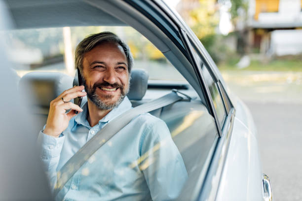 istock Happy man making a phone call in a taxi. 1264067928