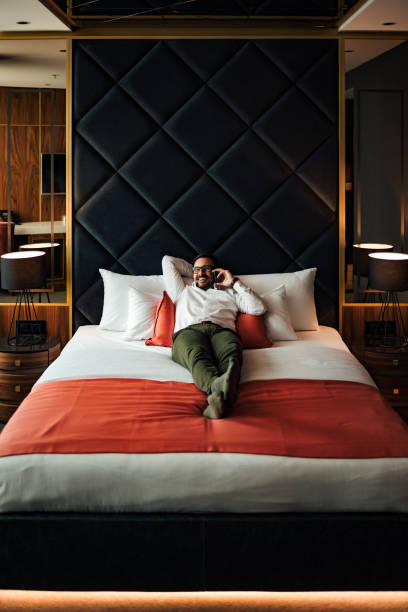 istock Portrait of a smiling elegant man having a phone call while lying on the bed. 1264067977
