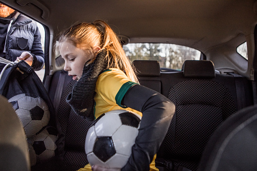 Soccer Father accompanying his daughter to football training by car