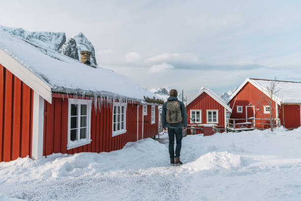 istock Man walking in Reine in winter, Lofoten 1264070384
