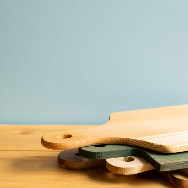 istock Wooden tray, cutting board, plate on wooden table with blue background 1264070548
