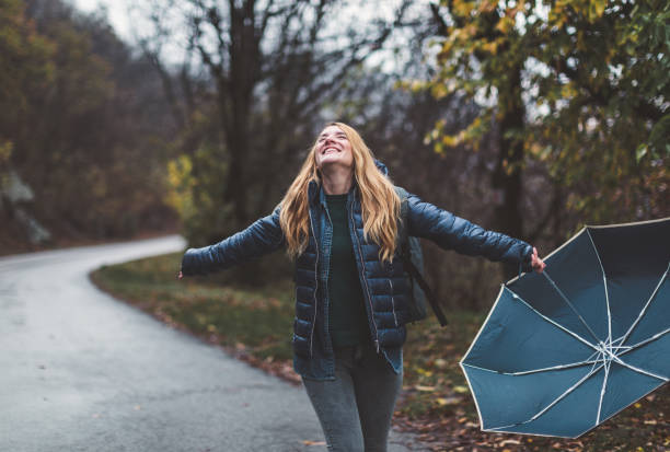 istock Joyful woman walking in rainy weather 1264072026