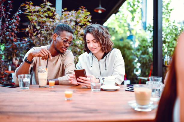 istock Multiethnic Couple Exploring Social Media While Enjoying Coffee And Juice 1264073921
