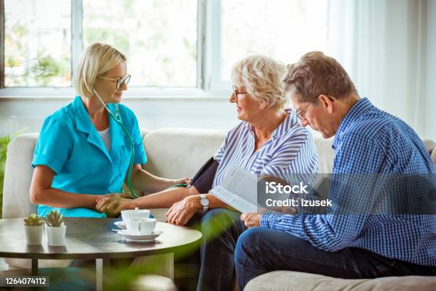 Home Nurse Checking The Blood Pressure Of The Elderly Lady Stock Photo - Download Image Now