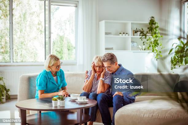 Nurse Talking With Worried Senior Couple Stock Photo - Download Image Now - Bad News, Cancer - Illness, Couple - Relationship