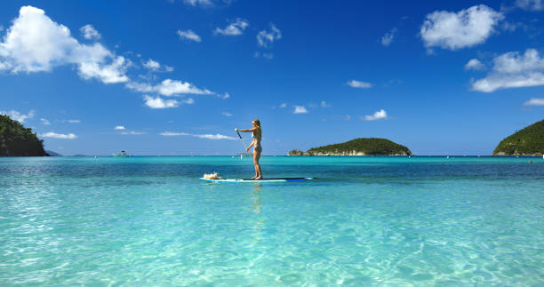 istock straw hat woman on a paddle board at tropical beach 1264074981