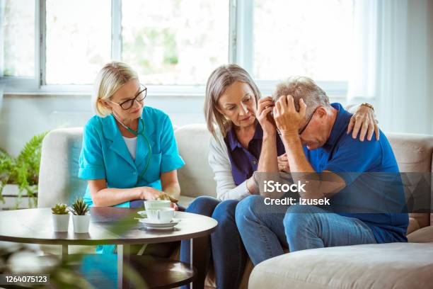 Nurse Talking With Worried Senior Man In Hospital Waiting Room Stock Photo - Download Image Now