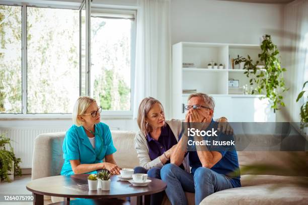 Nurse Talking With Worried Senior Man In Hospital Waiting Room Stock Photo - Download Image Now
