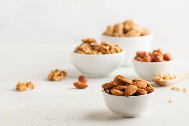 istock A handful of almonds in a white bowl, assorted nuts on a light background. Healthy snacks, healthy fats. Copy space. 1264075710