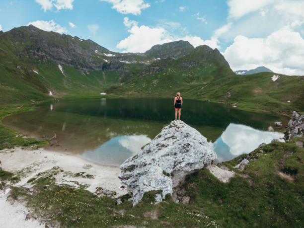 istock Young woman on mountain top contemplating view 1264077990