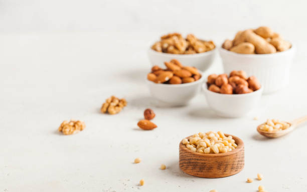 istock A handful of pine nuts in a wooden bowl, assorted nuts on a light background. Healthy snacks, healthy fats. Copy space. 1264078132