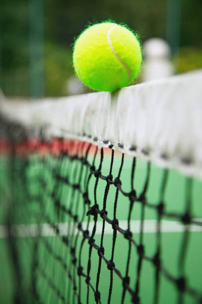 istock Tennis ball on tennis net 1264078797
