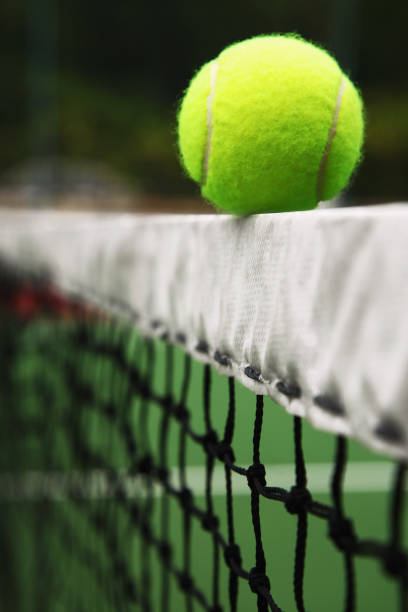 istock Tennis ball on tennis net 1264078929