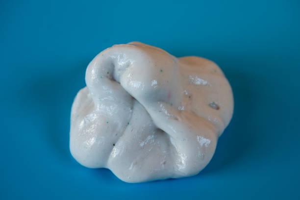 istock Kid Playing Hand Made Toy Called Slime on blue Background 1264079922