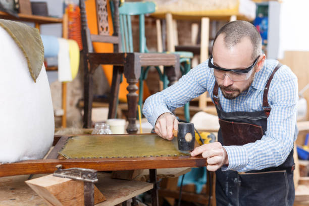 istock Craftsman reupholstering chair in workshop 1264081571