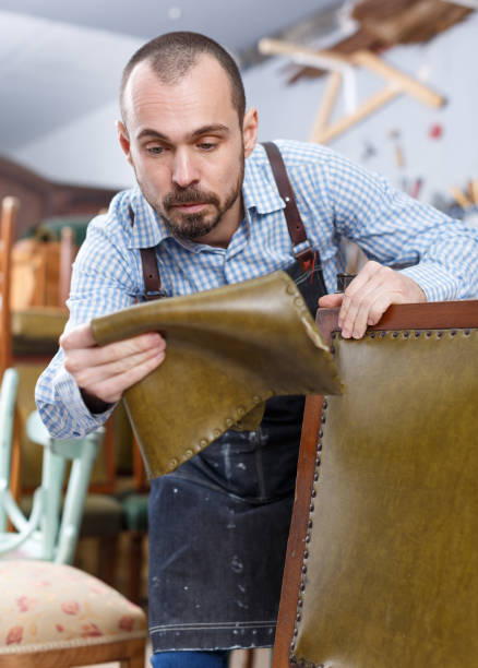 istock Craftsman reupholstering chair in workshop 1264081572