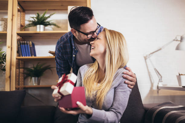 istock Happy couple with gift box at home celebrate Valentine's Day. 1264083049