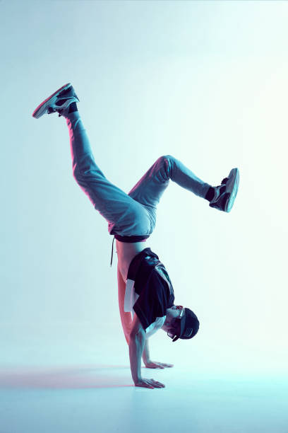 fajny młody breakdancer facet stoi na rękach taniec hip-hop w neonowym świetle. plakat szkoły tańca - dancing dancer hip hop jumping zdjęcia i obrazy z banku zdjęć