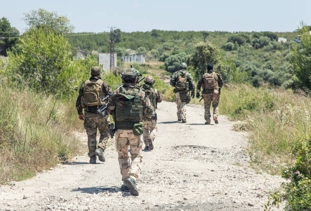 soldados del ejército equipo caminando, patrullando en el bosque - personal militar español fotografías e imágenes de stock