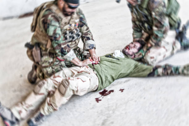 soldado dando atención de emergencia a camarada herido - personal militar español fotografías e imágenes de stock