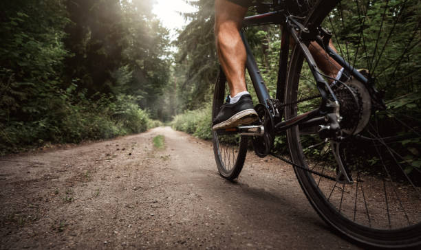 Close up of a biker on a bike Close up of a biker riding a bike through the forest road cycling photos stock pictures, royalty-free photos & images