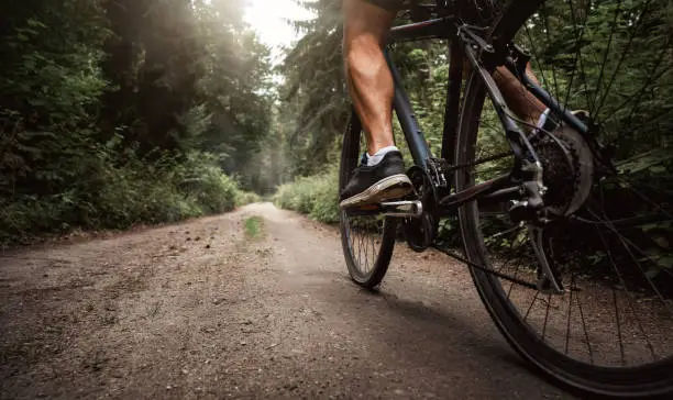 Close up of a biker riding a bike through the forest road